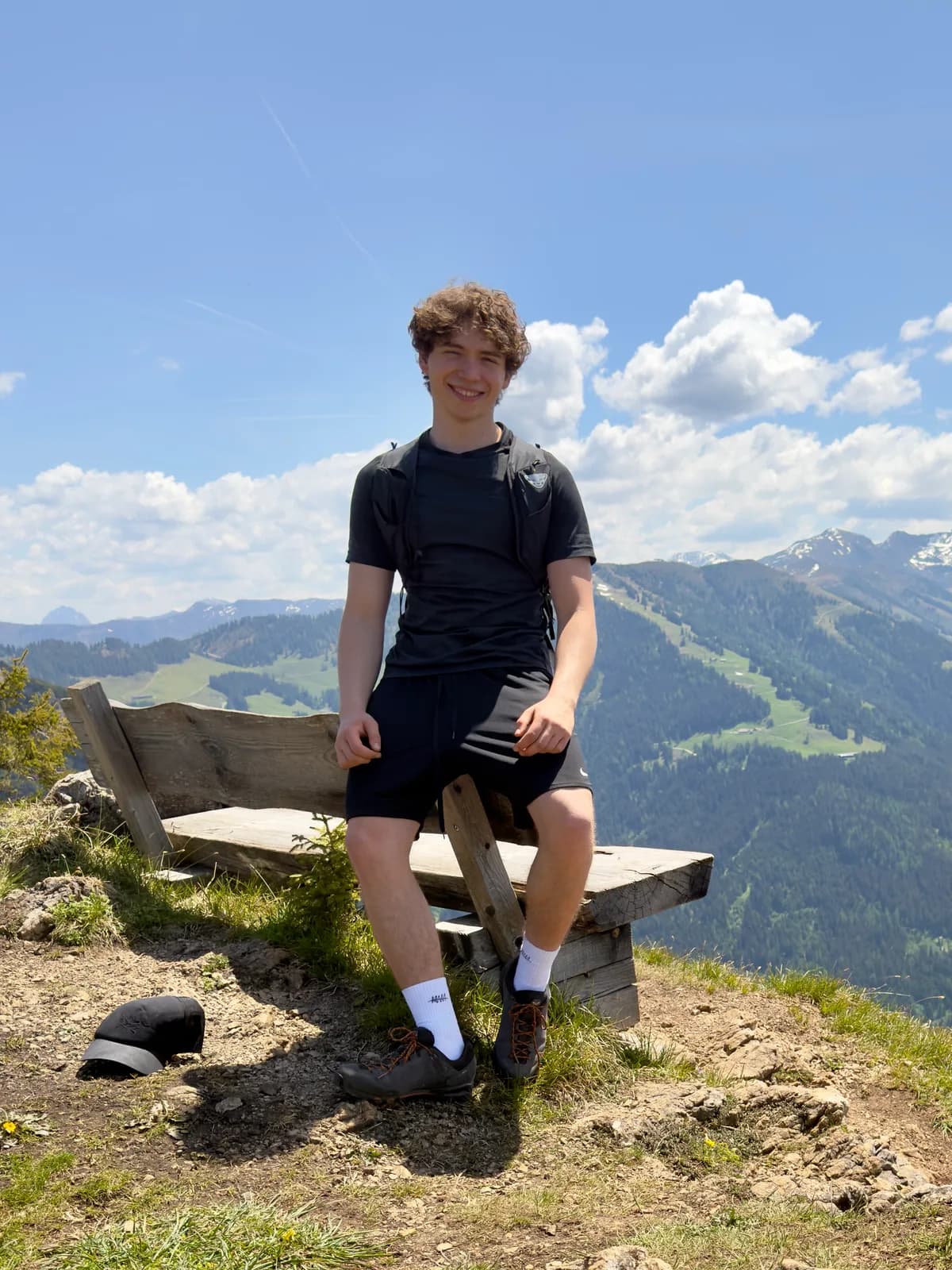 Fabio Zimmermann auf einer Bergbank, Tirol-Panorama im Hintergrund